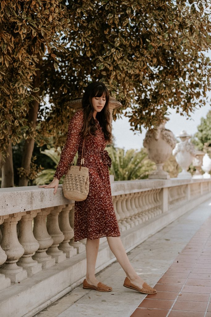 Nisolo Huarache Sandals with Sezane Alix Dress on woman standing against wall